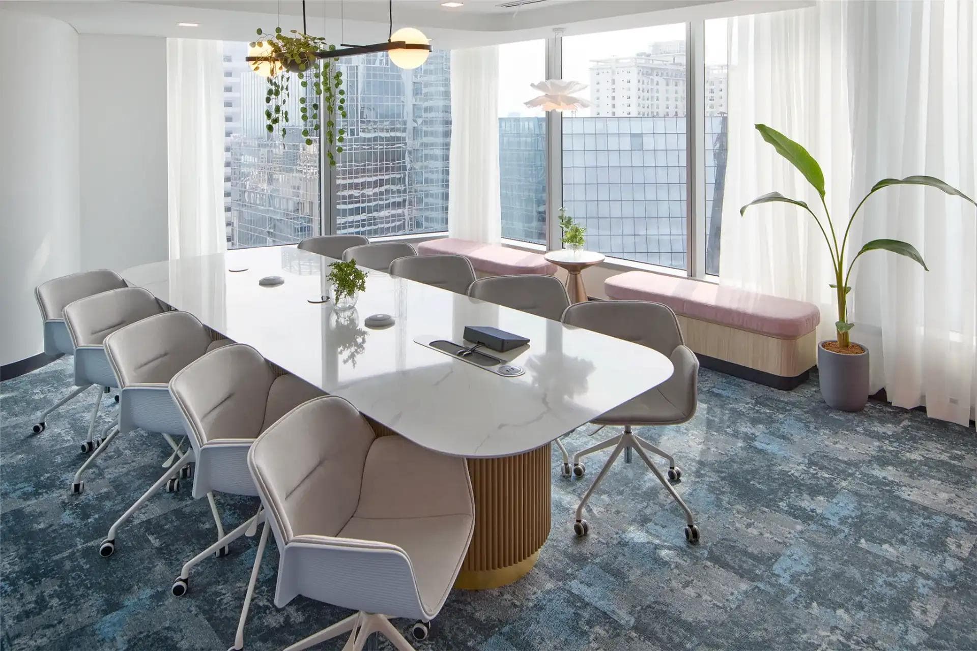 Modern meeting room in a Makati office space with marble table, swivel chairs, floor-to-ceiling windows, and city view.