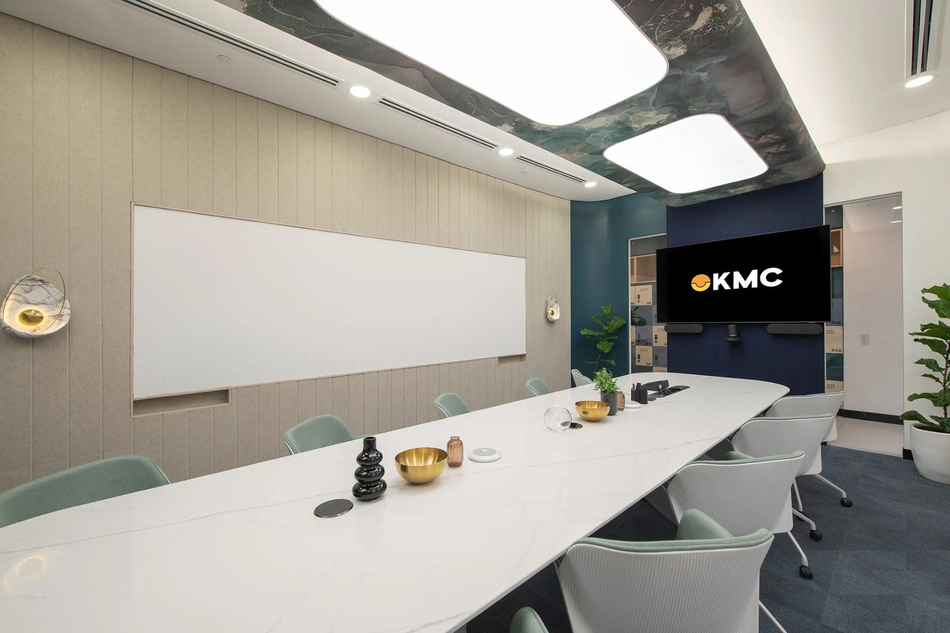 Sleek boardroom in a private office in One Ayala, Makati by KMC, with a marble table, plush chairs, and a wide TV screen.