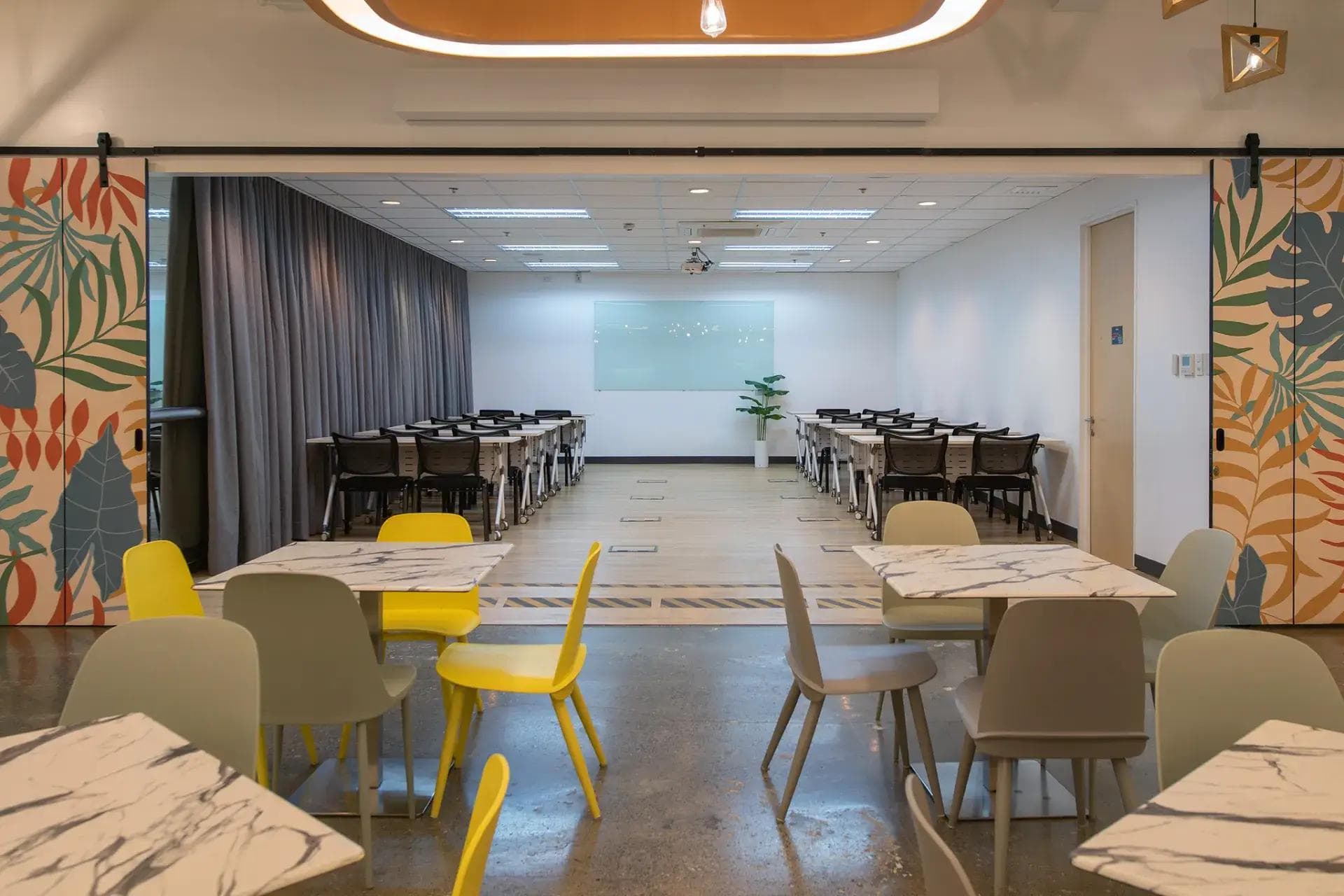 A versatile training room in Cebu with a projector, and a whiteboard, seamlessly connected to a stylish working space.