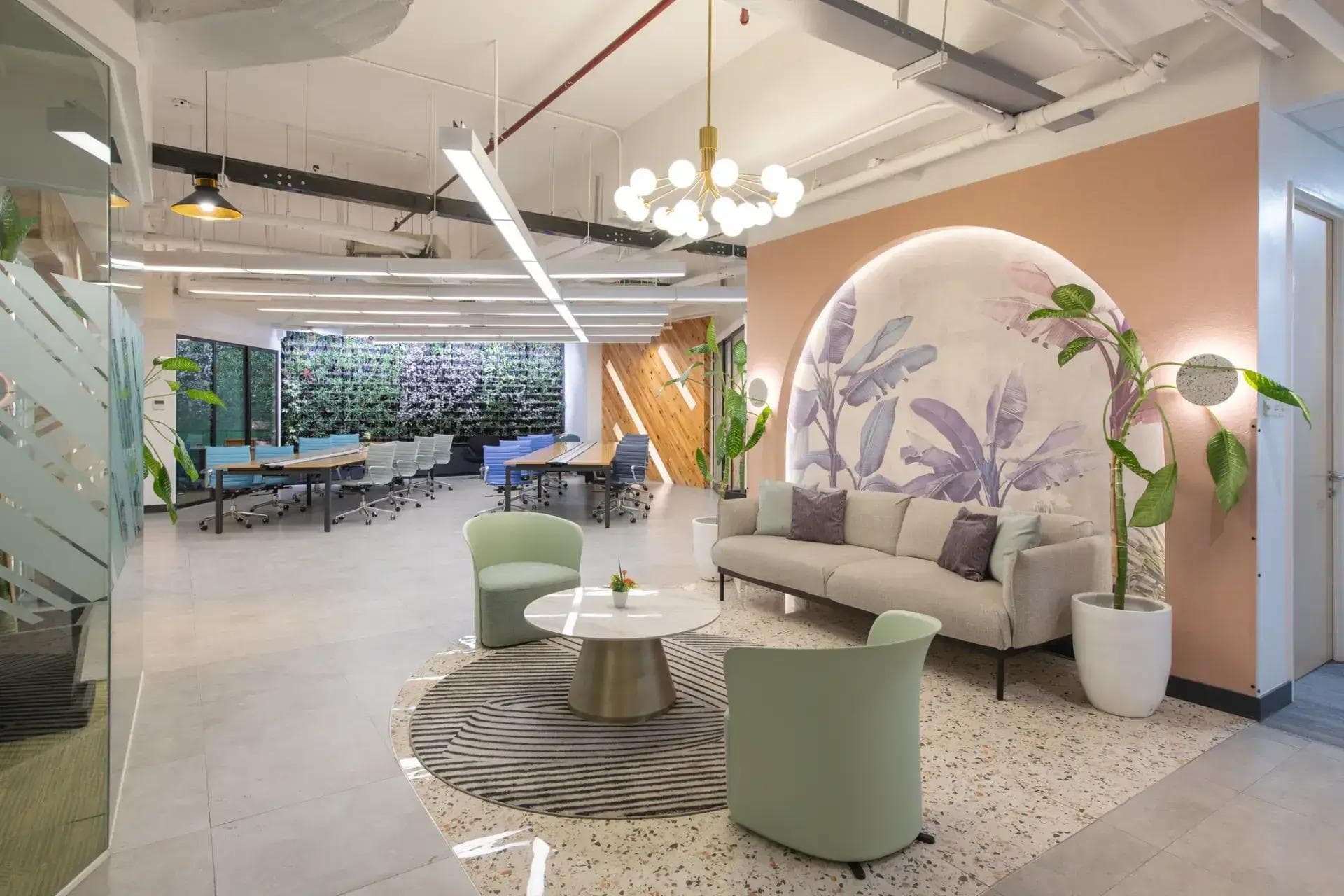Pastel-themed lounge at KMC Rockwell Sheridan, Mandaluyong office space with a leafy mural, soft seating, and lush decor.