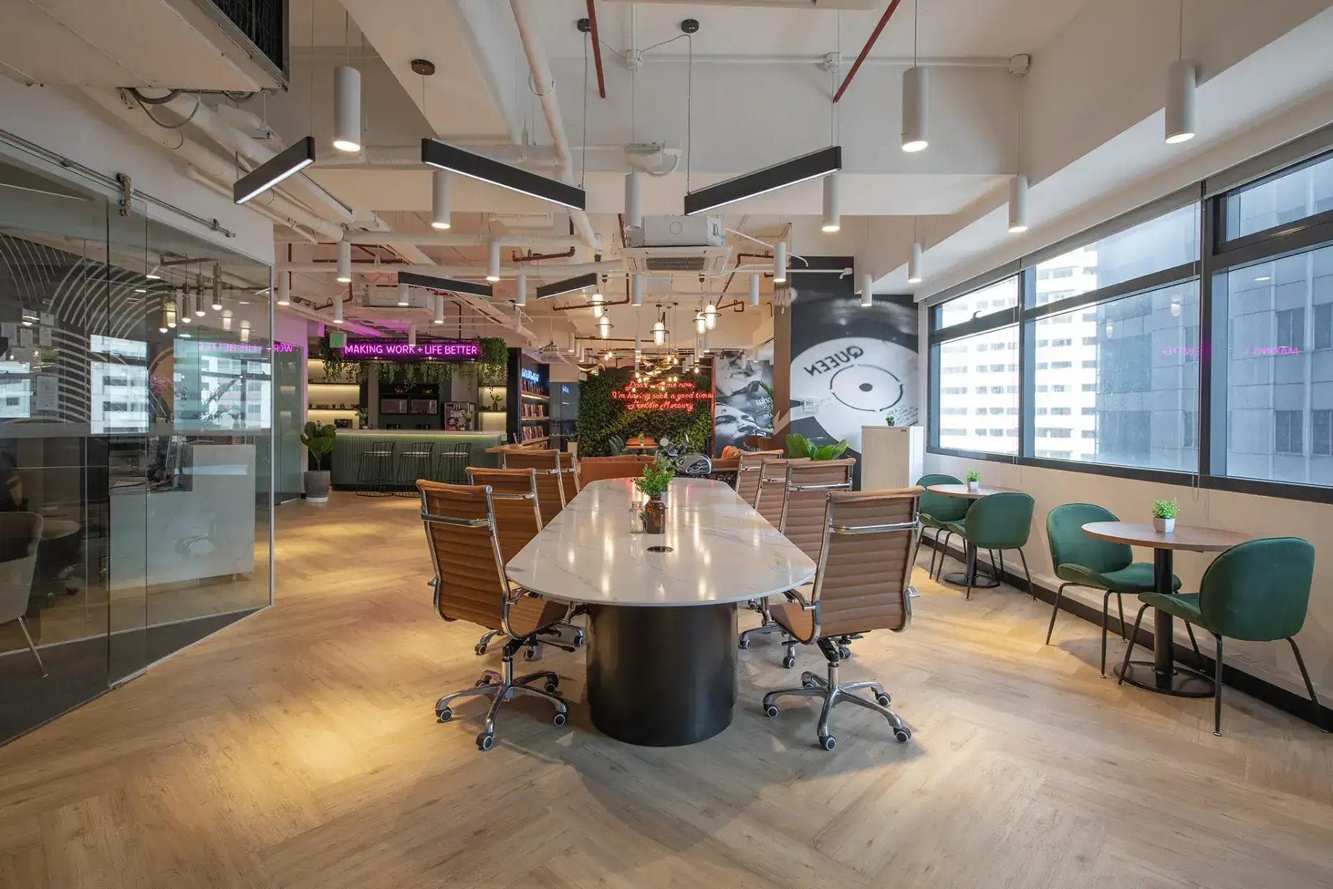 A stylish, open workspace with natural light, modern decor, collaborative setup and city views in the background.