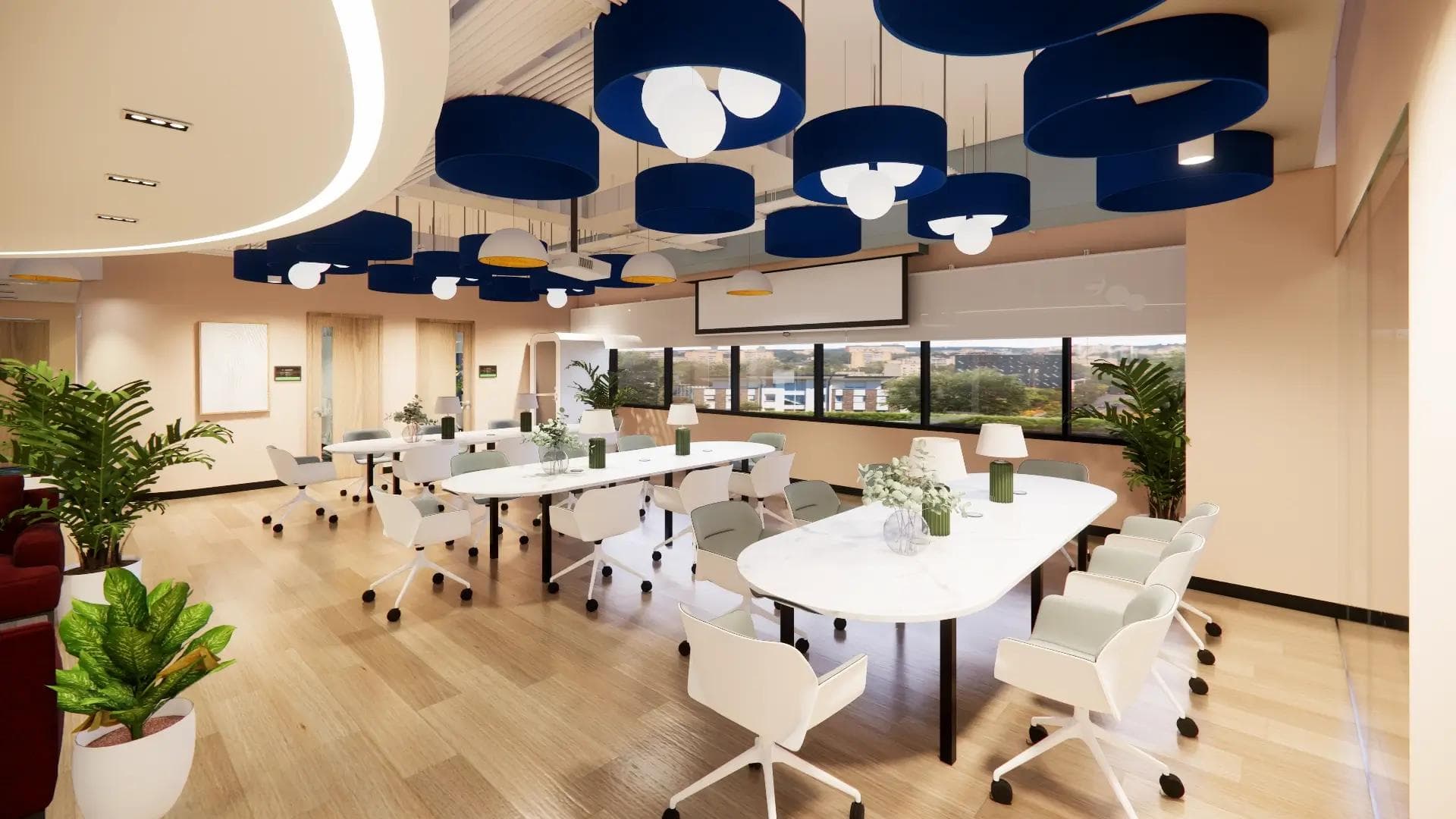 Bright coworking space with long white tables, modern chairs, blue ceiling lights, large windows, and lush green plants.