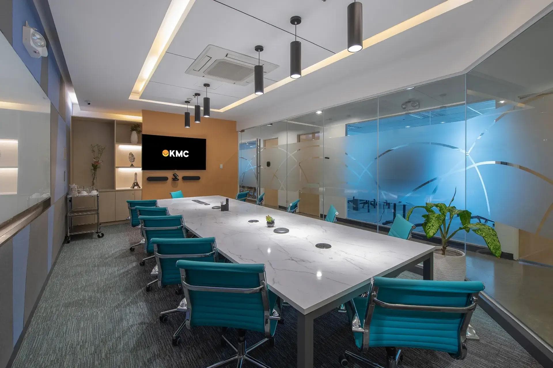 A private meeting room in Skyrise 4A, Cebu, with a marble table, teal chairs, glass walls and modern lighting.