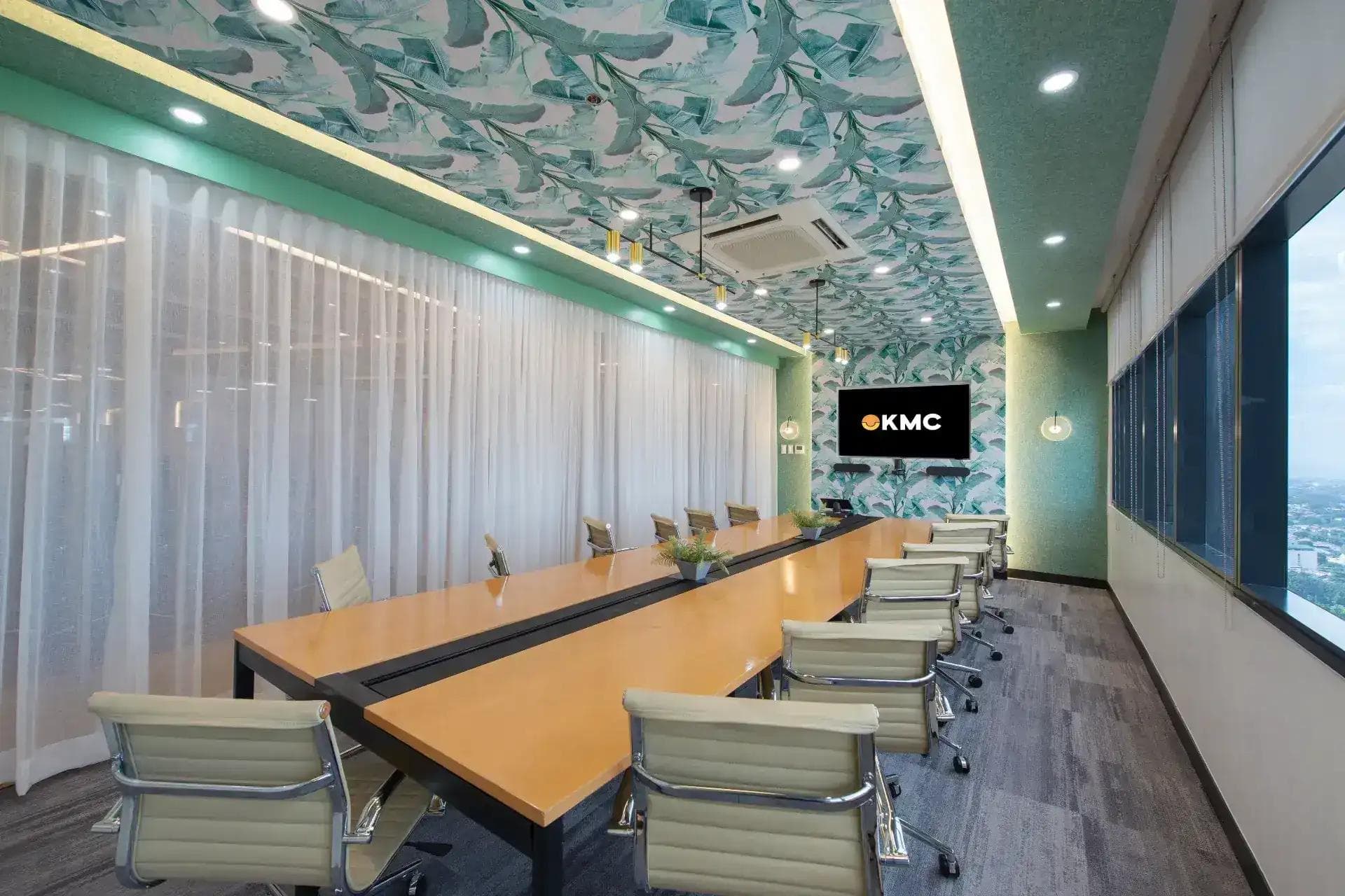A vibrant meeting room in Cybersigma, BGC - with a long wooden table, sleek cream leather chairs, tropical ceiling decor.